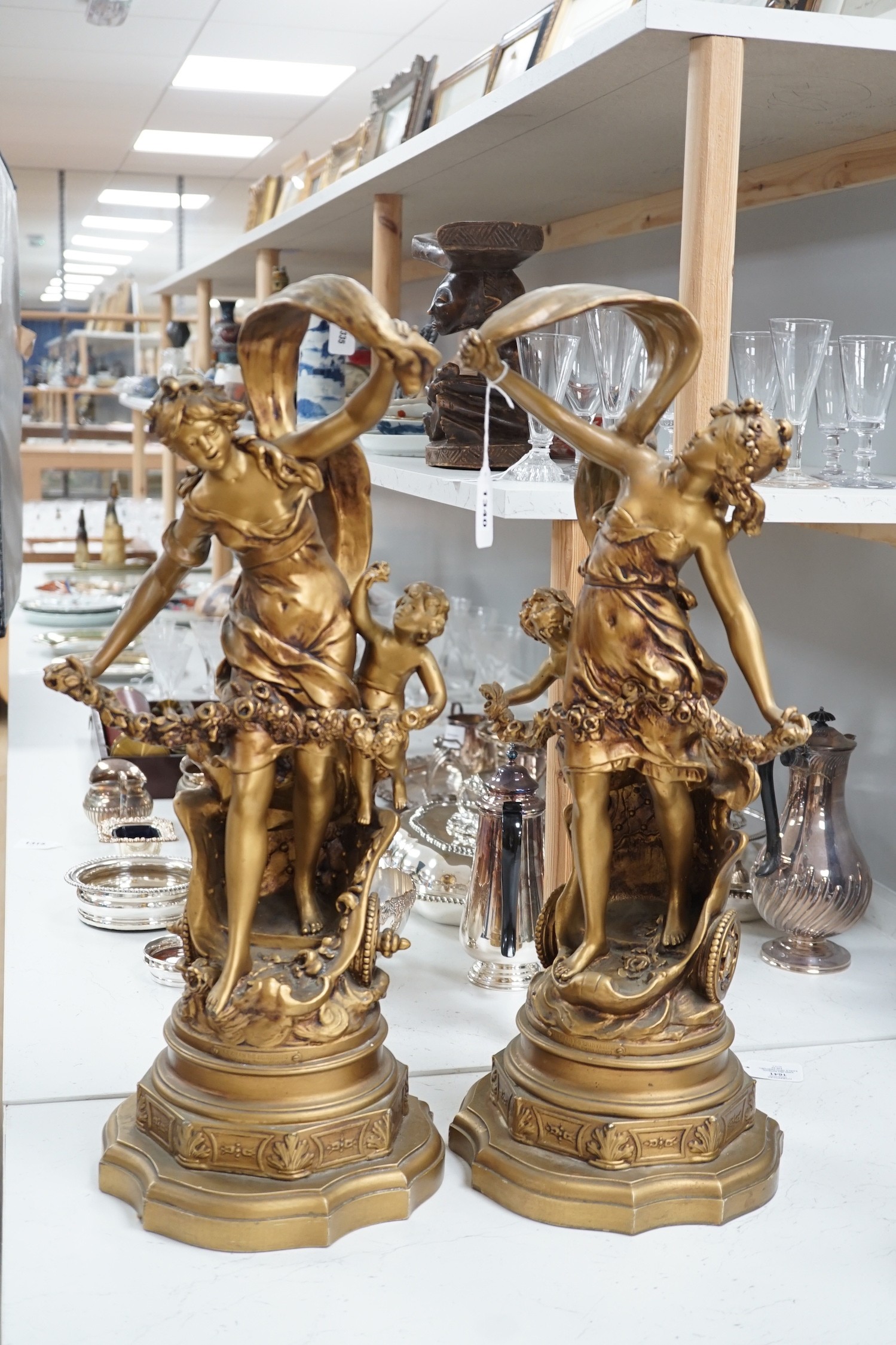 A pair of gilt spelter groups of a classical maiden and cherub, 61cm tall